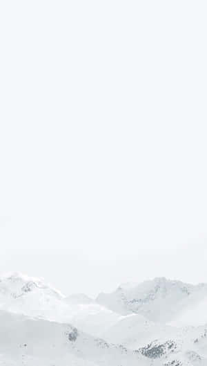 蒼白天空下的雪覆蓋山脈 — 白色 iPhone 壁紙