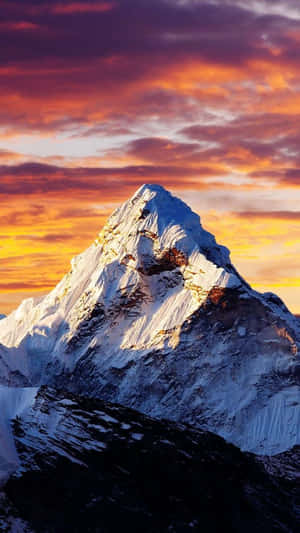 白雪覆蓋的山峰沐浴在金色夕陽光中，上方有彩色雲朵。 — 山景 壁紙
