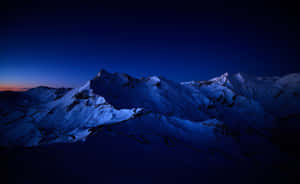 暮色中白雪覆蓋的山脈，下方有一條蜿蜒的道路，星空下。 — 黃昏 壁紙