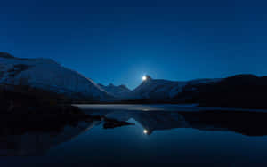 白雪覆蓋的山峰在星光下閃耀，倒映在夜晚平靜的湖面上。 — 湖泊 壁紙