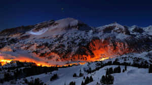 在星空下，溫暖燈光照亮的雪山。 — 雪景 GIF 壁紙
