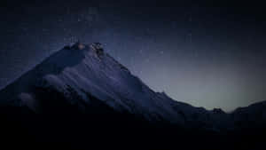 繁星點點的夜空下，白雪覆蓋的山峰與銀河系。 — 星星 壁紙