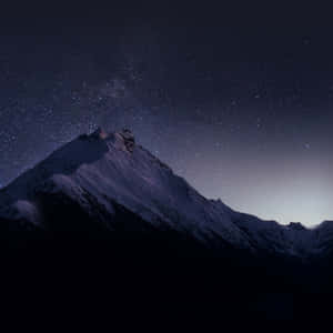繁星點點的夜空下，白雪覆蓋的山峰，銀河可見。 — 山脈 壁紙