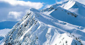 晴朗藍天與零星白雲下的雪山山脈。 — 雪山 壁紙