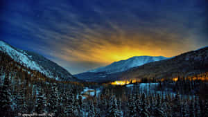 夜晚白雪覆蓋的山脈，星空和金色山谷。 — 山脈 壁紙