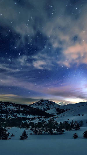星空下，白雪覆蓋的山脈與色彩斑斕的雲朵。 — 山脈 壁紙