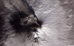 火山噴發，灰雲襯托著白雪覆蓋的山峰。 — 凋零風暴 壁紙