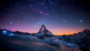 在帶有紫色和橙色色調的星空暮色天空下的白雪覆蓋的山峰。 — 宇宙 壁紙