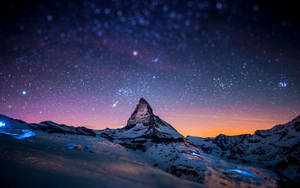 星空暮色下白雪覆蓋的山峰，帶有發光的藍色冰塊。