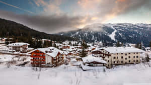 日落時分山區中白雪覆蓋的阿爾卑斯村莊 — 冬季風景 壁紙
