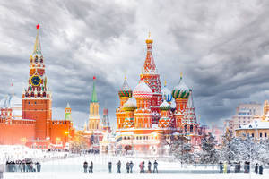 白雪覆蓋的聖巴西爾大教堂和克里姆林宮塔樓，人們在溜冰場上。 — 莫斯科 壁紙