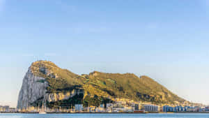 日落時分的直布羅陀巨岩，下方有沿海城市和遊艇碼頭。 — 岩石 壁紙