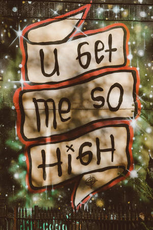 夜間磚牆上帶有閃光的塗鴉壁畫，寫著「u get me so high」。