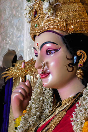 裝飾著金色王冠和花環的女神雕像。 — Maa Durga 壁紙