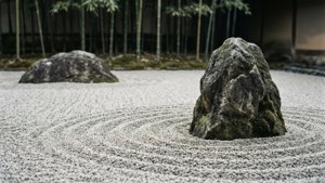 禪意庭園，有耙過的礫石和長滿苔蘚的石頭，周圍環繞著竹子。 — 靈性動圖 壁紙