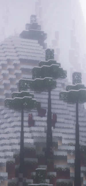 在霧氣瀰漫的Minecraft山景中，積雪的像素樹木。 — Galaxy A35 壁紙