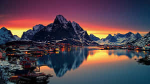 沿海村莊，紅色的房屋坐落在雪山之間，夕陽時分。 — 日落 壁紙