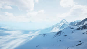 多雲天空下的雪山山脈，下方是冰凍的山谷。 — 雪山 壁紙