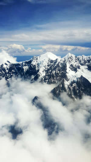 積雪的山峰在藍天下聳立於雲層之上。 — 瑞士 壁紙