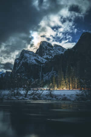 夜晚的積雪山峰與河流，閃爍的森林燈光 — 冬季美學 壁紙