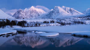 積雪的山峰在黃昏時倒映在結冰的河上。 — 冬季風景 壁紙