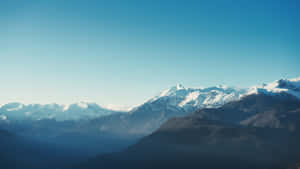 在清澈藍天和大氣薄霧下的積雪山脈。 — 山脈 壁紙