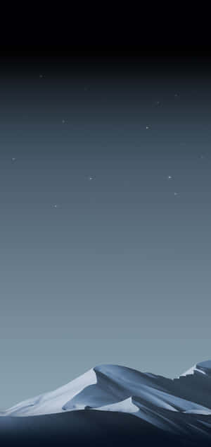 積雪的山峰在繁星點點的夜空下，帶有漸變的藍色調。 — iPhone 16 Pro 壁紙