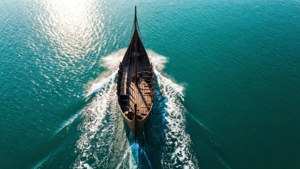 維京長船在碧綠海上航行，陽光照耀波浪