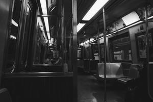 空無一人的地鐵車廂，一人在螢光燈下閱讀報紙。 — 地鐵 壁紙