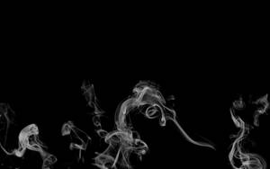 在黑色背景上飄動的俏皮煙霧圖案。 — 簡約暗黑美學 壁紙