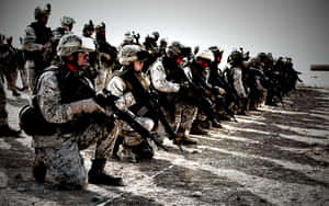 一排身穿沙漠迷彩的武裝士兵跪成隊形。 — 美國陸軍 GIF 壁紙