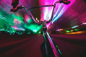 腳踏車把手在夜間穿過霓虹燈光 — 霓虹燈 壁紙