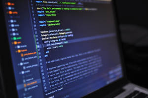 筆記型電腦螢幕顯示 Ruby on Rails 程式碼，鍵盤模糊。 — 3 個螢幕 壁紙