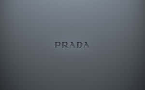 壓印在灰色紋理表面上的Prada標誌。 — 普拉巴斯 壁紙