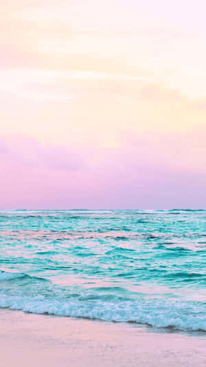 在粉彩日落天空下，碧綠海浪拍打粉紅沙灘。 — 海景 壁紙