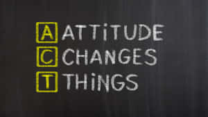 黑板上的粉筆字寫著「Attitude Changes Things」，A C T 以黃色突出顯示。 — 1280x720 壁紙