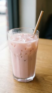 粉紅冰奶茶加冰塊和竹吸管在木桌上 — 淺粉色調 壁紙