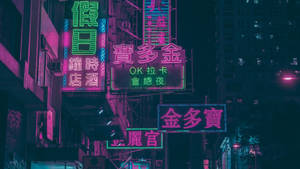 霓虹燈以粉紅色和綠色色調照亮了夜晚密集的城市天際線。 — 霓虹紫 壁紙