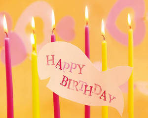 魚形卡片上的Happy Birthday訊息，配有點燃的粉紅色和黃色蠟燭。 — 生日 壁紙