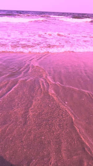 粉紅色的海浪在紫色天空下沖刷濕沙。 — 粉紅色美學桌面 壁紙