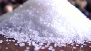 深色木質表面上的粗白鹽結晶堆 — 甜食控 壁紙