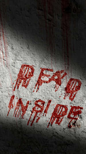 在聚光燈下粗糙的混凝土牆上，血紅色塗鴉寫著 fear inside。 — 殭屍動圖 壁紙