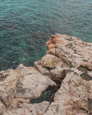 日光下的海岸懸崖，帶有粉紅色岩石和碧綠的海浪。 — 海洋桌面 壁紙