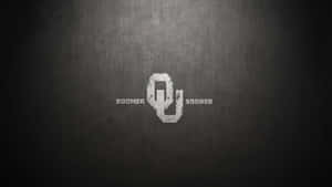 Oklahoma Sooners 標誌，帶有 boomer sooner 文字，置於有紋理的灰色背景上 — 奧克拉荷馬 壁紙
