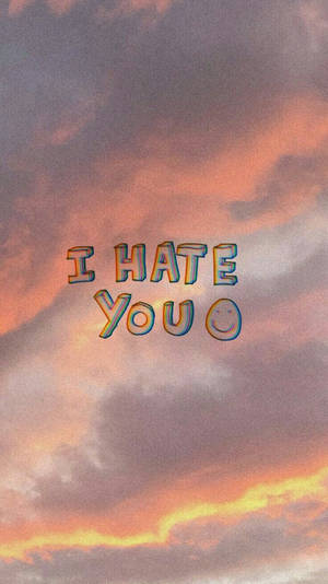文字寫著「I HATE YOU」並帶有笑臉，背景是色彩繽紛的日落天空。 — 夕陽天空 壁紙