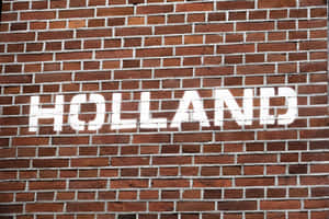 紅磚牆上的白色模板字 holland。 — 磚牆 壁紙