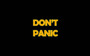 黑色背景上的黃色文字寫著don't panic — 驚爆危機 壁紙