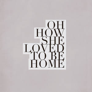 在灰色紋理背景上交錯的黑色文字引用，寫著「Oh how she loved to be home」。 — 首頁 壁紙