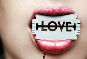紅色嘴唇含著刻有LOVE字樣的剃鬚刀片，血滴下。 — 語錄 壁紙