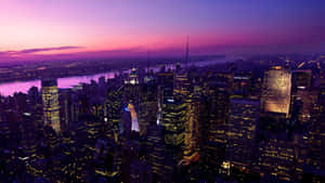 紐約市天際線在黃昏時，閃爍的建築物和紫色的天空。 — 紐約市 壁紙